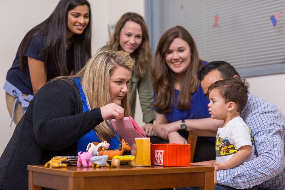 Department of Communication Sciences and Disorders professor and students work with pediatric patient.