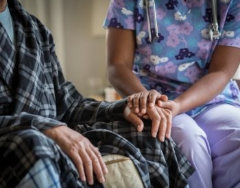Nurse talks with patient living with dementia.