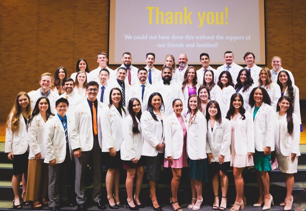 Doctor of Physical Therapy students wear their new white coats at ceremony.