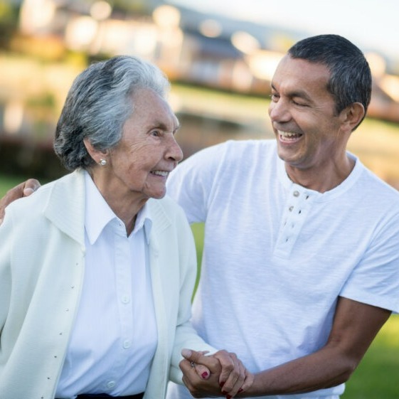 Male caregiver assists elderly woman