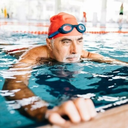 Older man swimming in pool