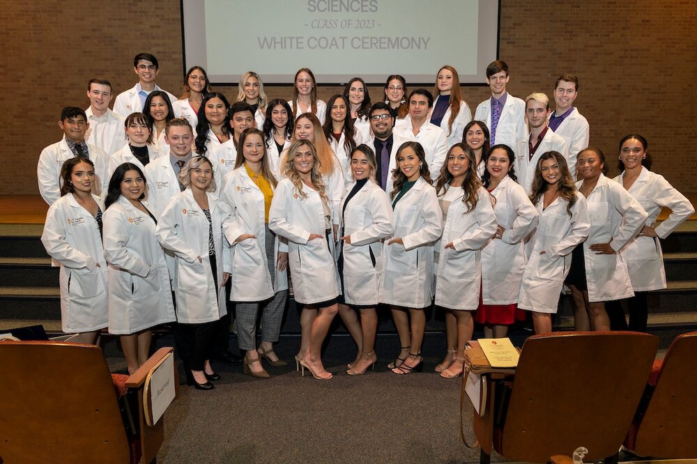MLS students pose in white coats. 